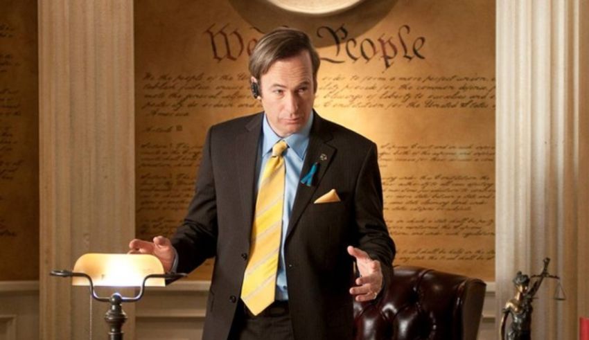 A man in a suit and tie standing in front of a desk.