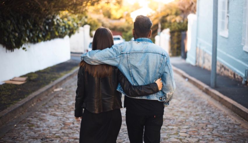 A couple walking down a cobblestone street.