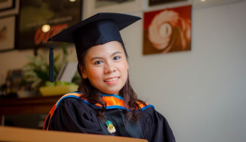 A woman in a graduation gown smiling for the camera.