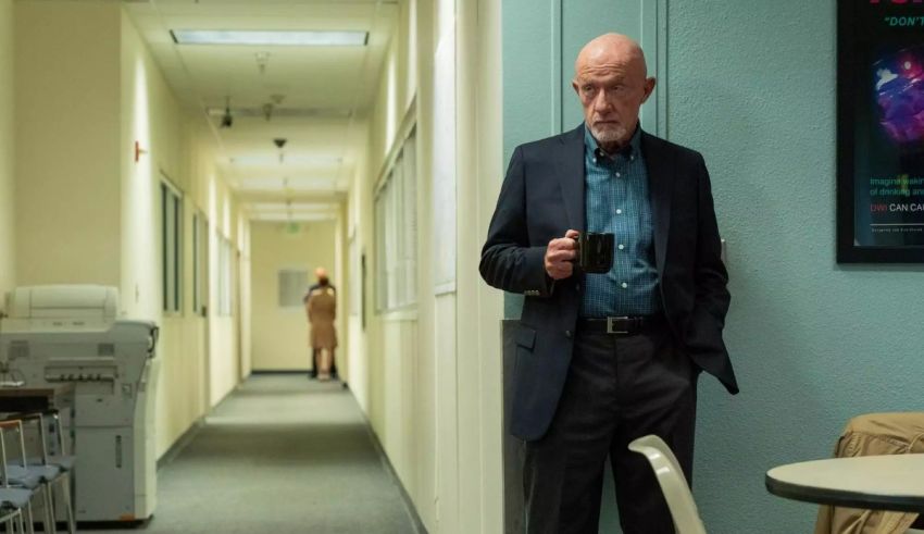 A man standing in a hallway with a cup of coffee.