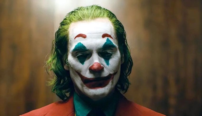 A joker in a red suit with green hair.