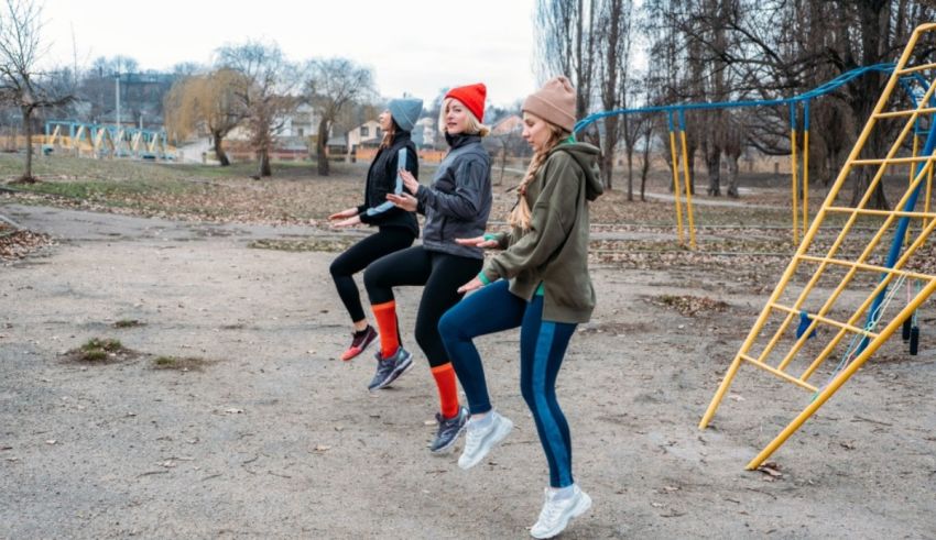 Three women are jumping on a playground in the park.