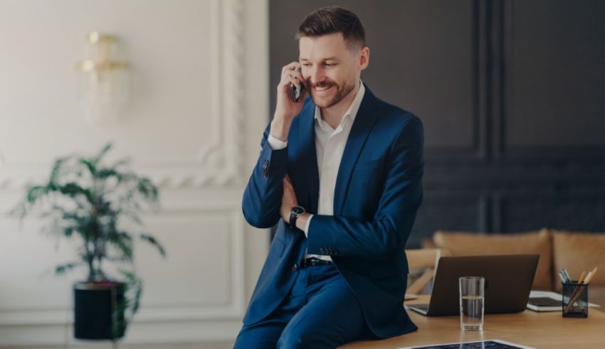 A man in a suit is talking on the phone in an office.