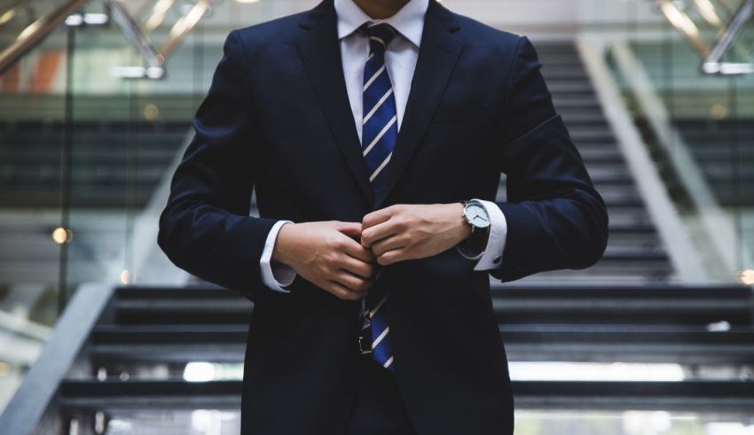 A man in a suit is adjusting his watch.