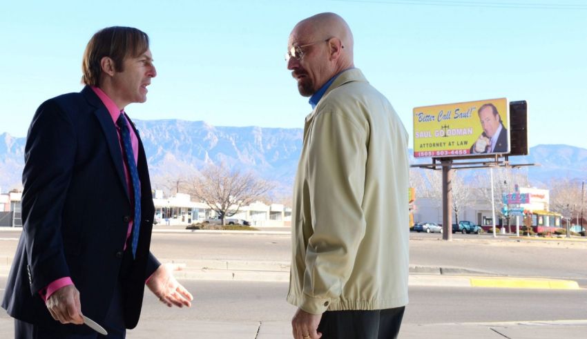 Two men in suits talking on a street.