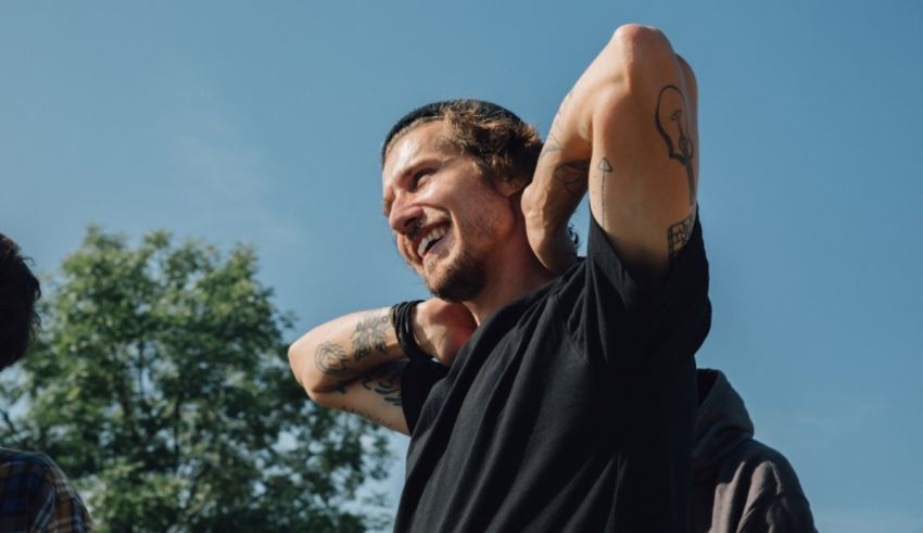 A man with a tattoo on his arm and another man with a tattoo on his arm.