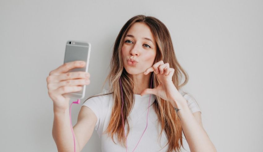 A young woman is taking a selfie with her phone.