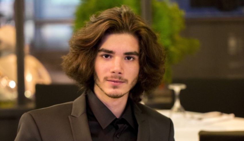 A young man in a suit and tie poses for a photo.