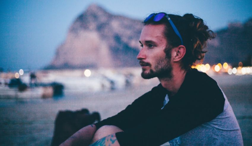 A man sitting on the beach at night.