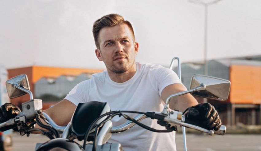 A man is riding a motorcycle in a parking lot.