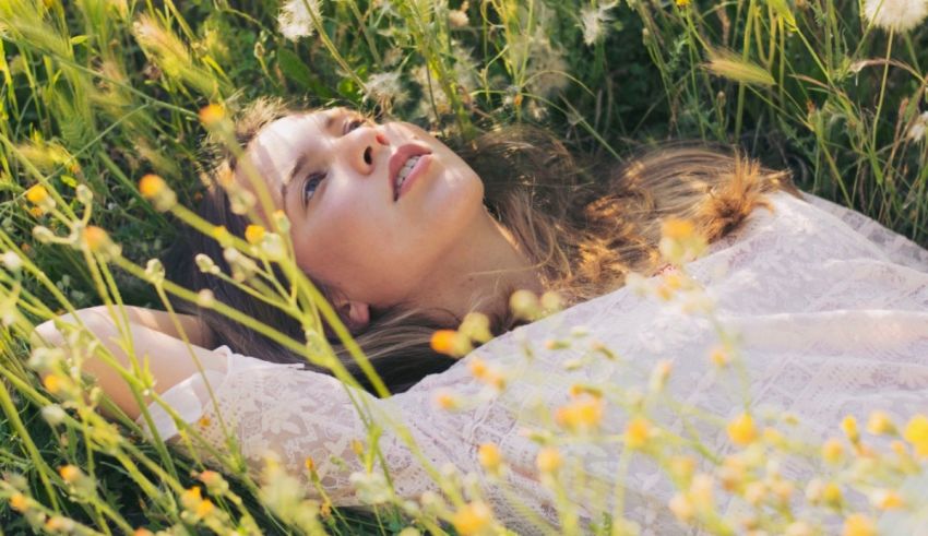 A young woman laying in a field of wildflowers.