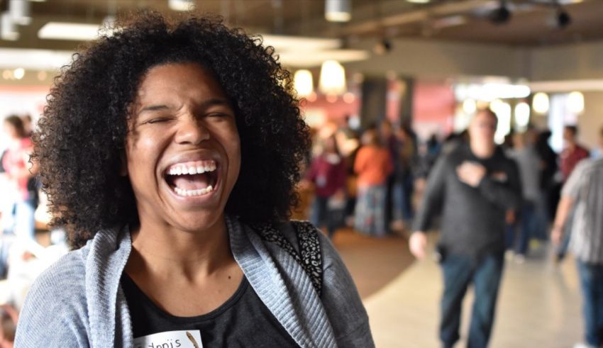 A woman laughing in a crowd of people.