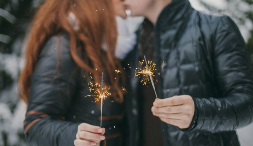 A couple kissing with sparklers in the snow.