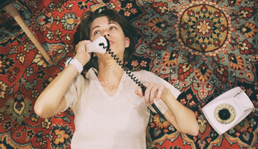 A woman talking on a phone on a rug.