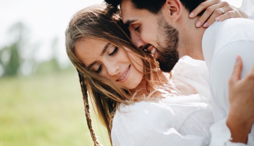 A man and woman hugging in a field.