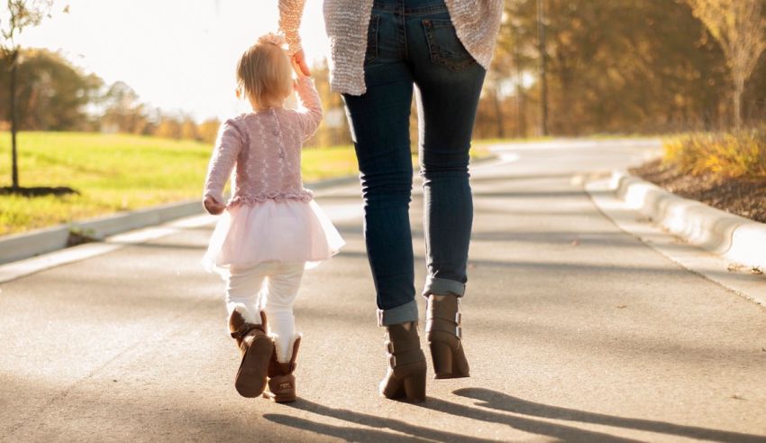 A mother and daughter walking down a road.