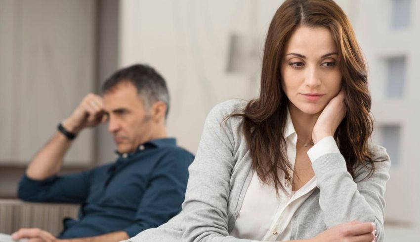 A man and woman sitting in front of a laptop.