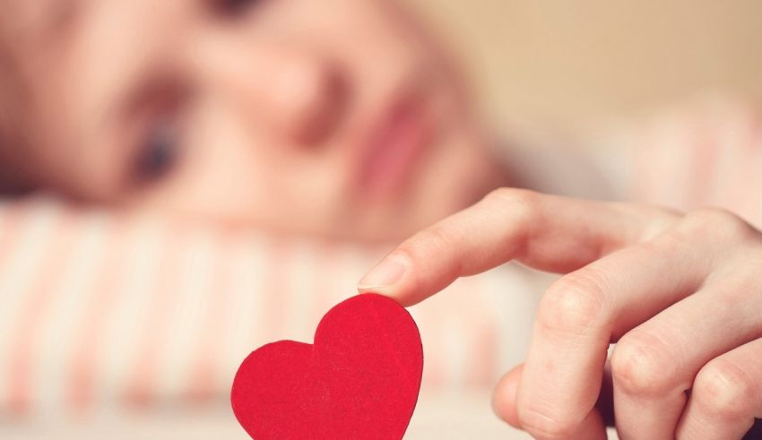 A girl holding a red heart in her hand.