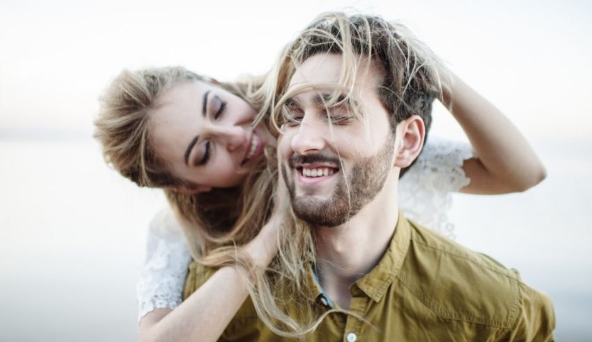 A man and a woman hugging each other on the beach.