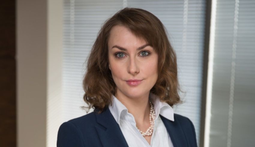 A woman in a business suit is posing for a photo.