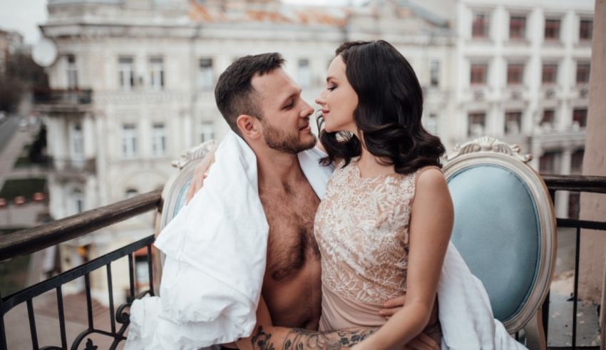 A man and a woman kissing on a balcony.