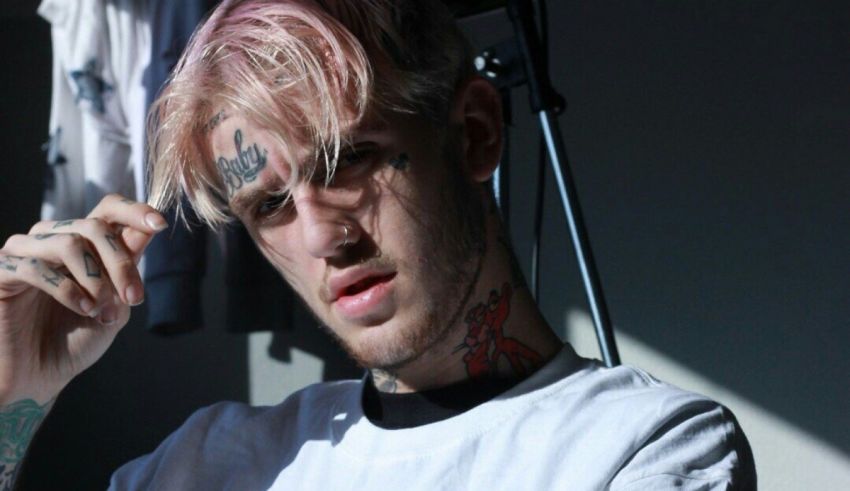 A young man with pink hair and tattoos.