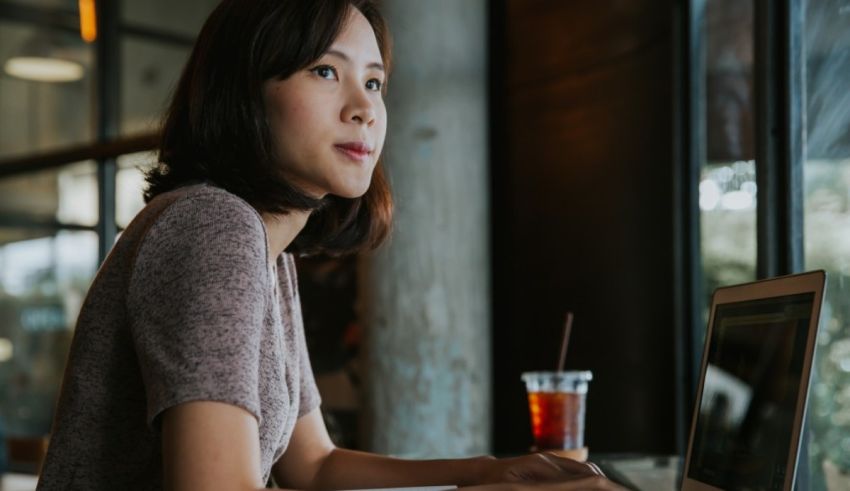 A woman is working on her laptop in a cafe.