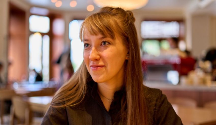A young woman sitting at a table in a restaurant.