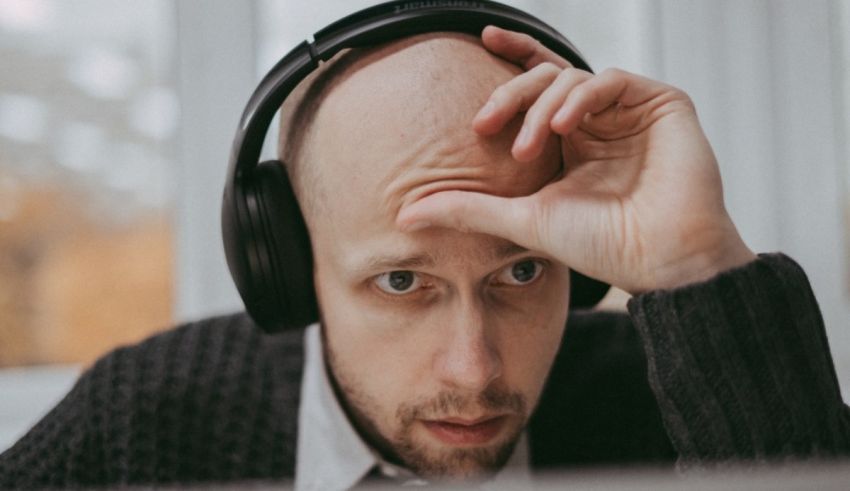 A bald man with headphones on his head.