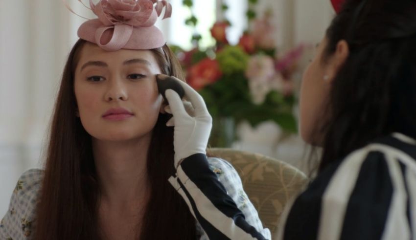 A woman is getting her makeup done by another woman.