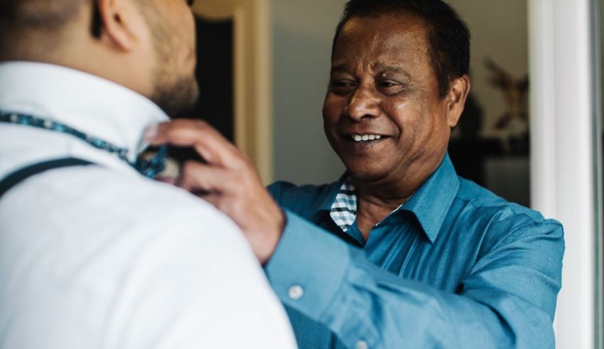 A man adjusting a man's tie.