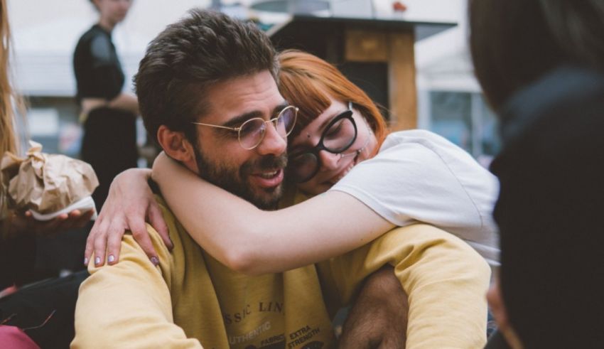 Two people hugging each other at an outdoor event.