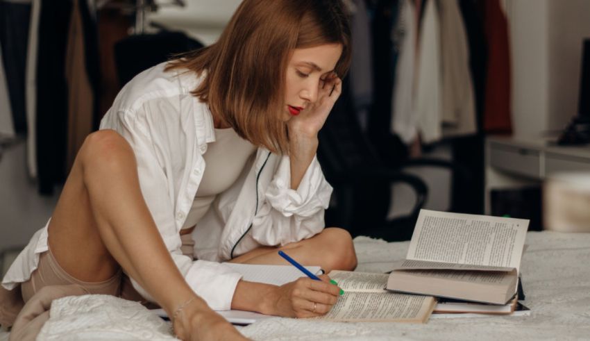 A woman is sitting on a bed reading a book.