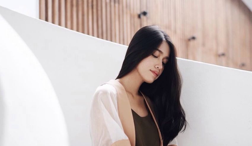 A young woman leaning against a wall.