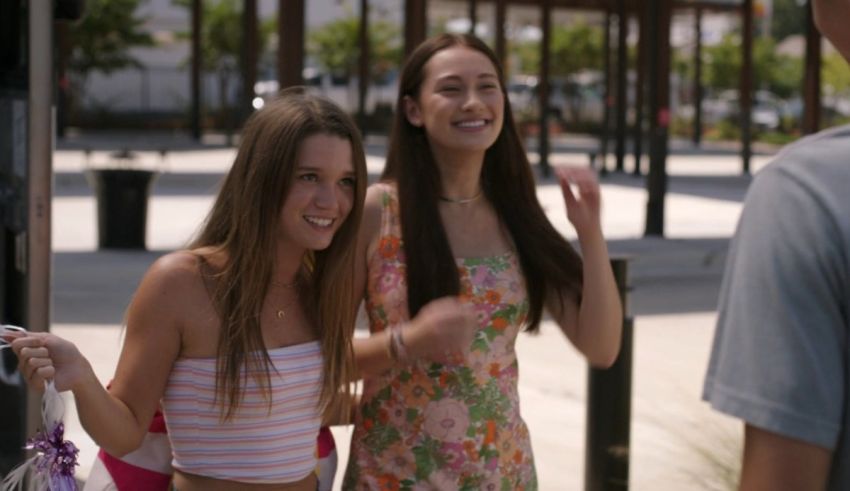 Two girls standing next to each other in front of a store.