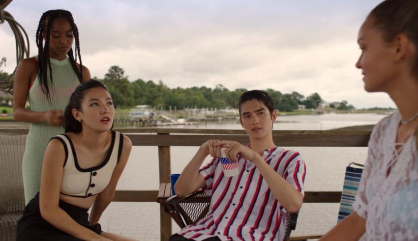 A group of people sitting on a dock talking to each other.