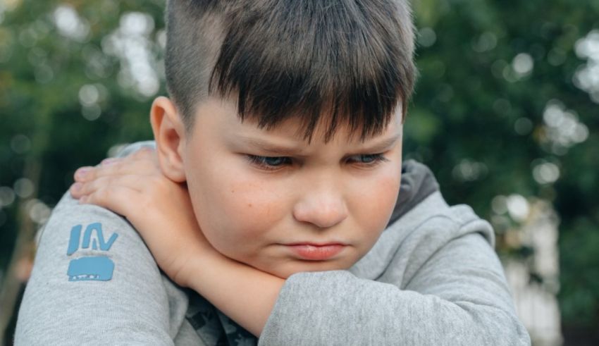 A young boy with his hand on his shoulder.