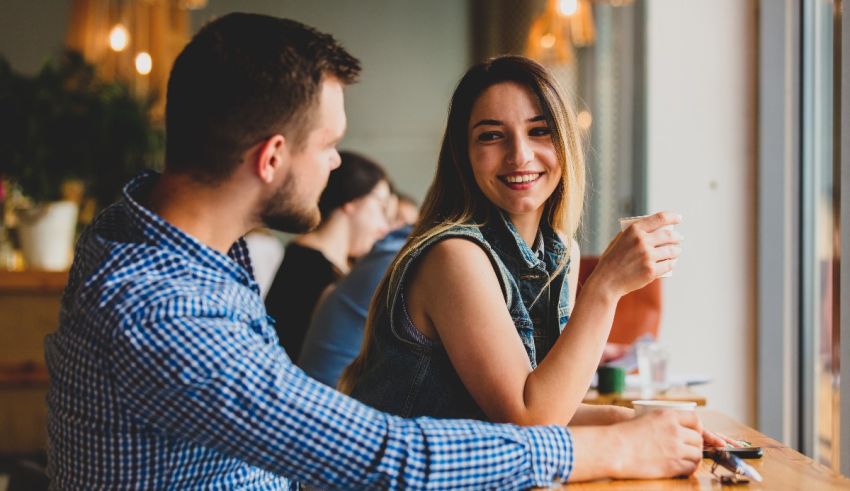 A man and woman sitting at a table in a cafe.