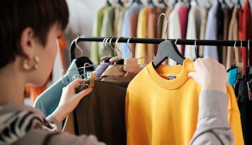 A woman is looking at clothes on a rack.