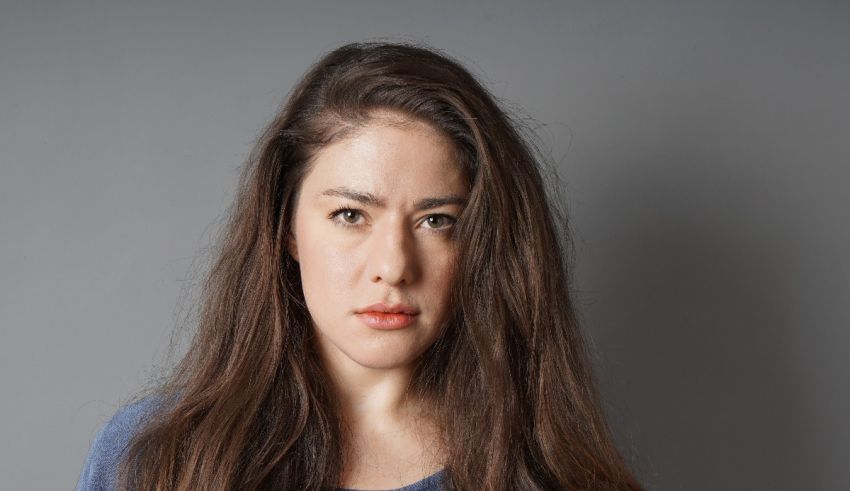 A woman with long hair is looking at the camera.