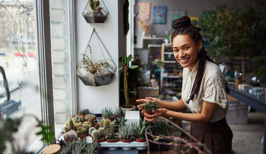 A woman is holding a potted plant in front of a window.