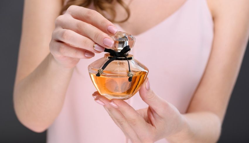 A woman holding a perfume bottle in her hands.