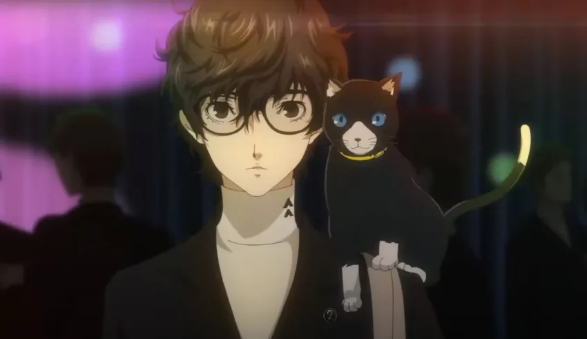 A man with glasses holding a cat in front of a crowd.