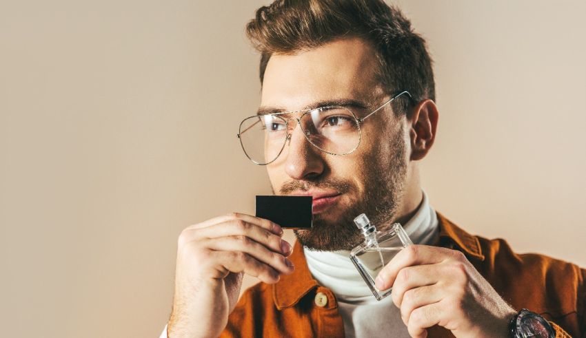 A man with glasses is holding a credit card.