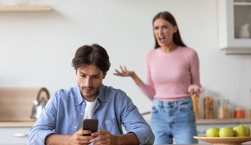 A woman is looking at her phone while a man is looking at it.