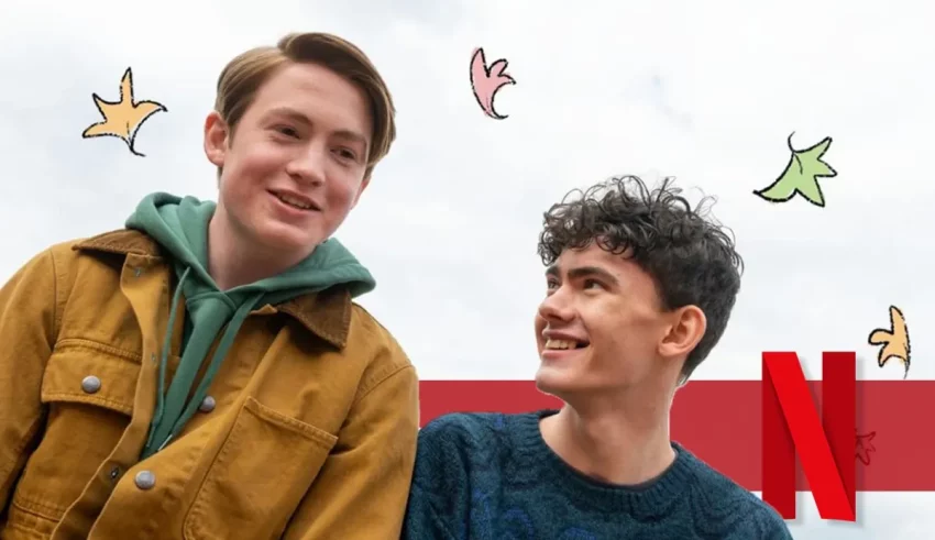 Two young men are smiling in front of a netflix poster.