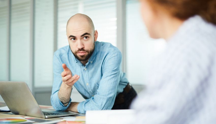 A man is talking to a woman in an office.