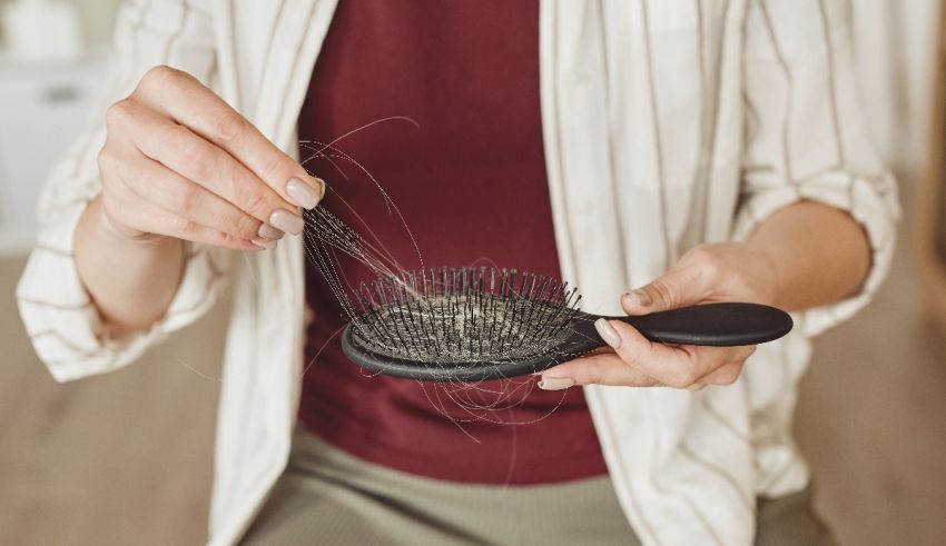 A woman is combing her hair with a brush.