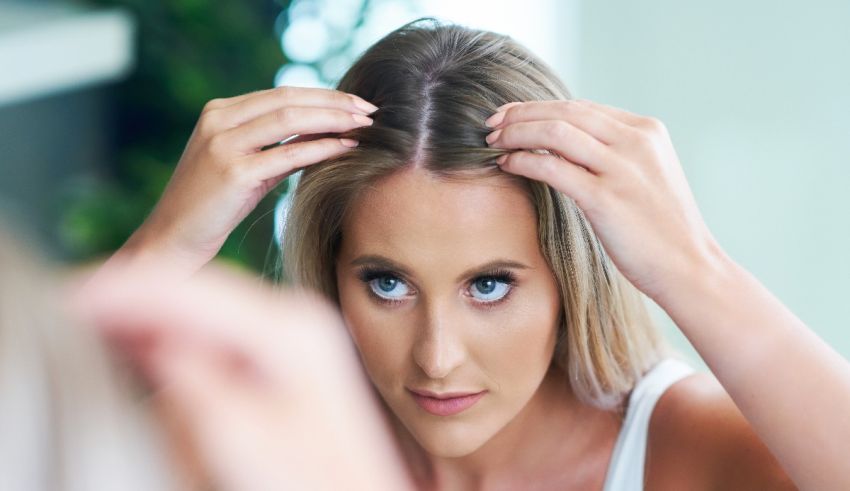 A woman is combing her hair in front of a mirror.