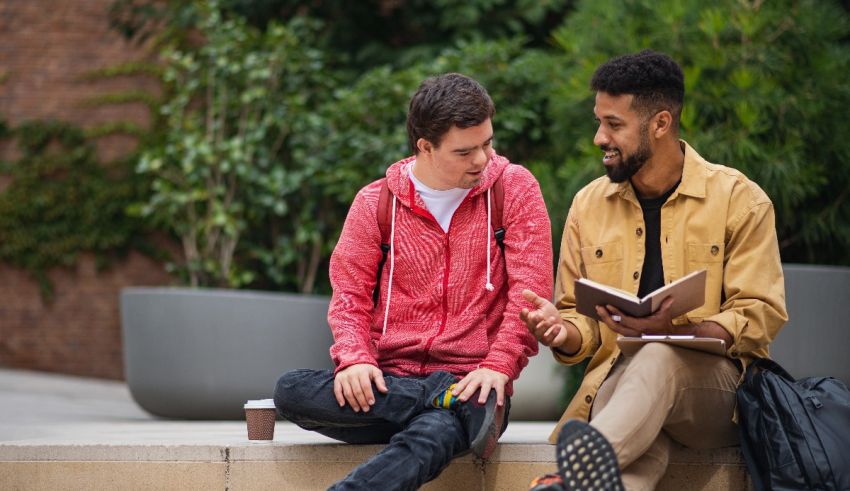 Two students sitting on the steps and reading a book.